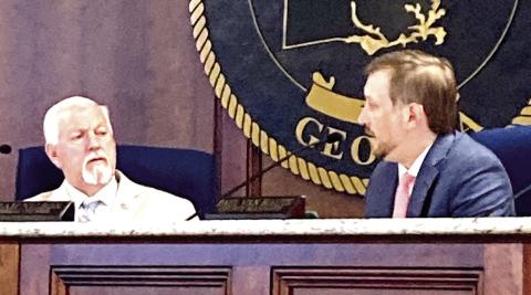 Two Putnam County commissioners discuss topics during a recent meeting. (LYNN HOBBS/Staff)