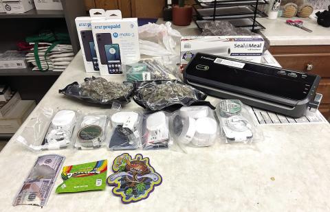 The vacuumedsealed bags of marijuana, cell phones and tobacco products intercepted by Eatonton police officers is displayed on a table. Also, the sealing equipment and other drugrelated items were seized. CONTRIBUTED/EPD