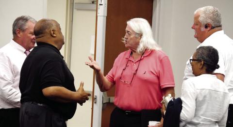 Eatonton Mayor John Reid (left, in black) and citizen Don Sadler exchange words following last Tuesday’s Putnam County Commission meeting, with County Manager Paul Van Haute (far left), citizen Karen Garrett, and Putnam County Fire Chief Thomas McClain looking on. IAN TOCHER/Staff