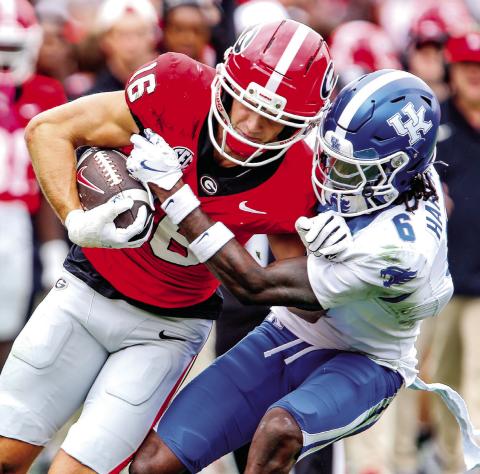 Georgia wide receiver London Humphreys (16) tries to stay in bounds while fighting off Kentucky defensive back JQ Hardaway (6). LANCE McCURLEY/Staff