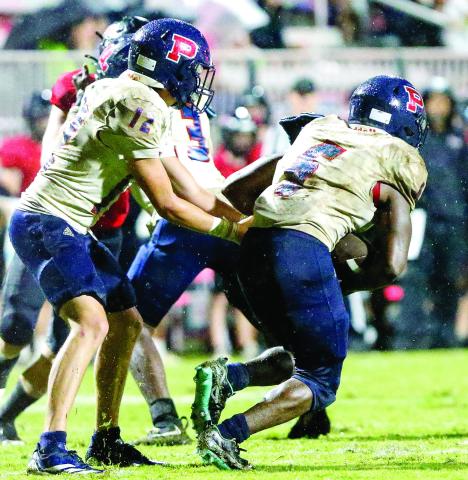 Putnam County quarterback Ethan Whatley (12) hands the ball off to running back Omarion Butts (6) during a game against Morgan County on Friday, Aug. 22. LANCE McCURLEY/File photo