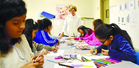 Kids make “Thankful feathers” under the guidance of instructor Nancy Marshall. As they color the feathers, they also write down things that make them feel thankful.