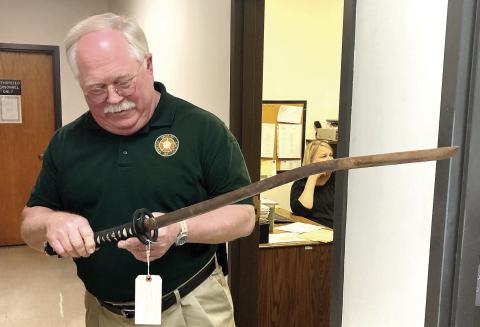 Putnam County Sheriff Howard Sills shows the samurai sword that was used in a recent attack on a man and his vehicle. LYNN HOBBS/Staff