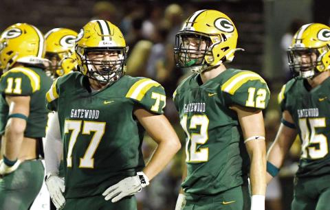 Gatewood juniors Drew Burke (77) and Sean Bennett (12) share a moment during a break in play against Augusta Prep last month at Sammons Field in Eatonton. IAN TOCHER/File photo
