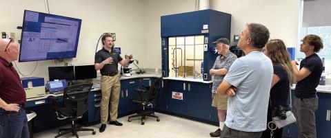 Piedmont Water lab supervisor Kyle Craig (second from left) speaks to visitors about his work in the site’s microbiology lab. SKYLA MORRIS/Staff