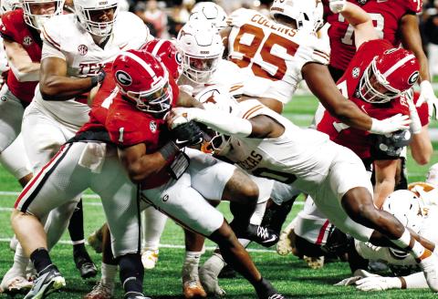 Georgia running back Trevor Etienne (1) fights his way through Texas defenders to score the game-winning touchdown in overtime. LANCE McCURLEY/Staff