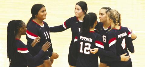 Several Lady Eagles celebrate after winning a point against Lake Oconee Academy. ARELLA CASH/Staff