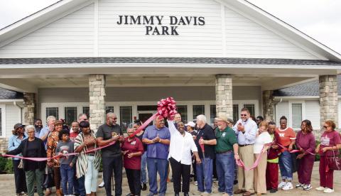 City of Eatonton Councilmember Janie Reid holds the bow high after Putnam County Chairman Bill Sharp (holding scissors beside her) cut the ribbon on Saturday to officially reopen Jimmy Davis Park, south of downtown. IAN TOCHER/Staff