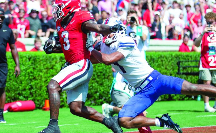 Georgia running back Nate Frazier (3) shrugs off a defender as he crosses the goal line.