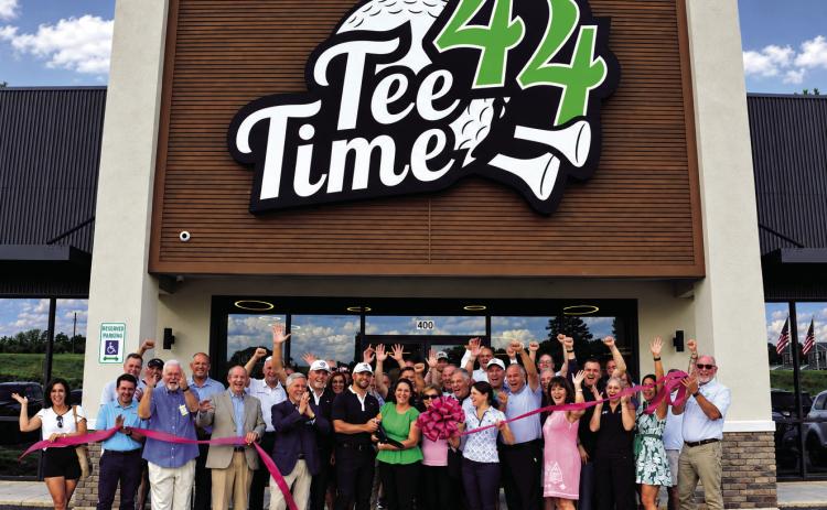 The ribbon falls to officially open Tee Time 44 last Thursday, a new electronic golf training and bar/restaurant for gourmet-seeking golf enthusiasts.